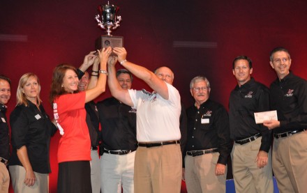 Lake Travis activity coordinators, school board members and the superintendent (far right) celebrate the Lone Star Cup win at the district convocation ceremonies. Assistant Athletic Director Traci Neely presented the trophy and a $1,000 check to Superintendent Brad Lancaster.