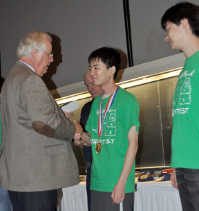 At the UIL Academic State Meet, Math Contest Director Larry White congratulates junior Bobby Shen from Dulles High School for his perfect score on the test. Shen won four individual gold medals at the meet.