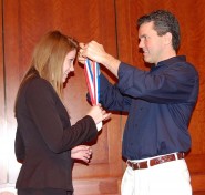State Representative Mark Strama, a member of the House Education Committee, medals a student at the CX State Meet. Rep. Strama spoke to the students about the impact debate had on his life.