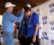 Dr. Greg Poole, the newly elected Legislative Council Chair, drapes medals on winners at the Cross Country State Championship