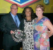 Sam Tipton standing with Sheila Henderson, UIL assistant athletic director, and his wife Audree, displays his 
