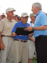 UIL Executive Director Charles Breithaupt presents an appreciation plaque to Max Goldsmith who coached the 1965 3A national record holder in the 400-meter relay at Andrews High School.