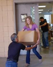 Brooke Keeler, athletic administrative associate, helps load the donated T-shirts to Eastside Community Connection.