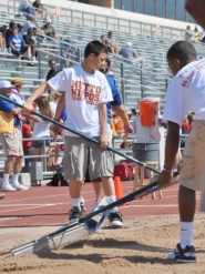 Hutto High School students rake the sand pits before state competitors begin the long jump competition at the 2011 State Track and Field Meet. 